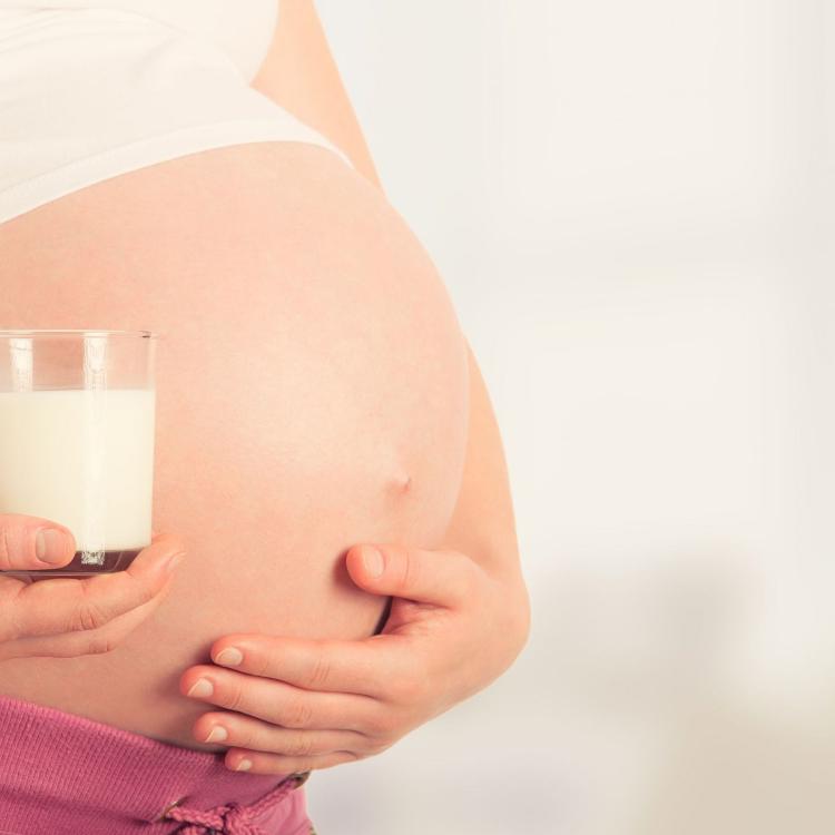 15628440 - concept of healthy nutrition and pregnancy. belly of pregnant woman and a glass of milk