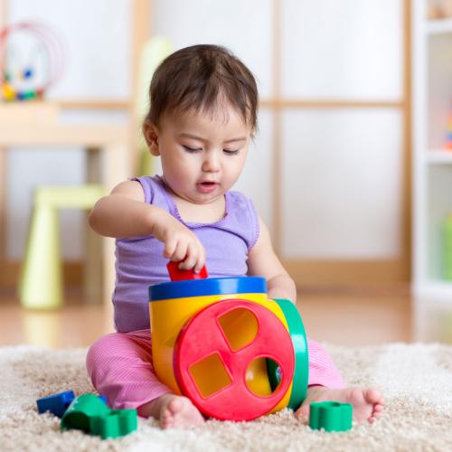 54307076 - cute toddler girl playing indoors with sorter toy sitting on soft carpet