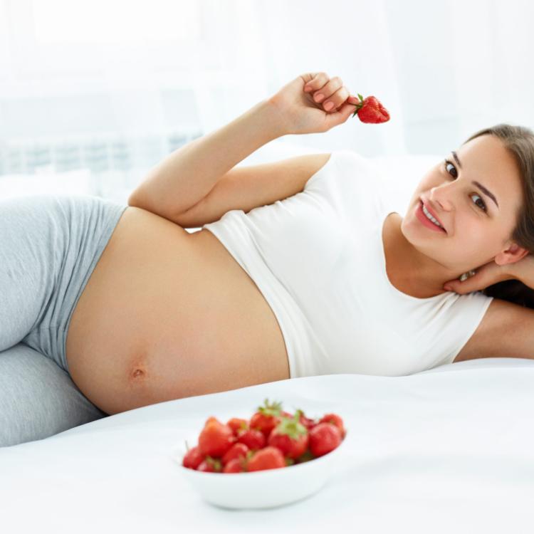 Pregnant Woman Eating Strawberry at home. Healthy Food Concept. Healthy Lifestyle. Diet