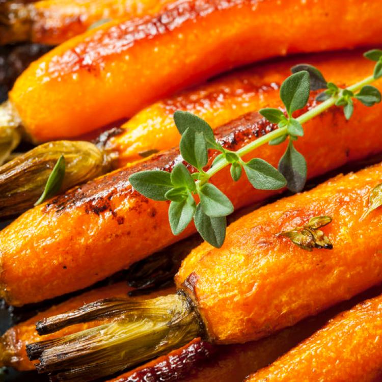 27705667 - roasted baby carrots garnished with thyme.
