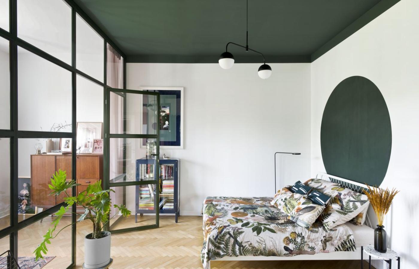  Przeszklona ściana z metalu między pracownią a sypialnią dzieli, a zarazem łączy oba pomieszczenia (Fot. Jakub Pajewski)
