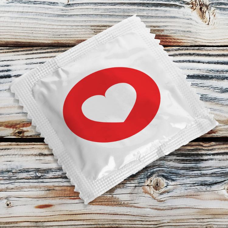 49661866 - condom with heart on wooden table