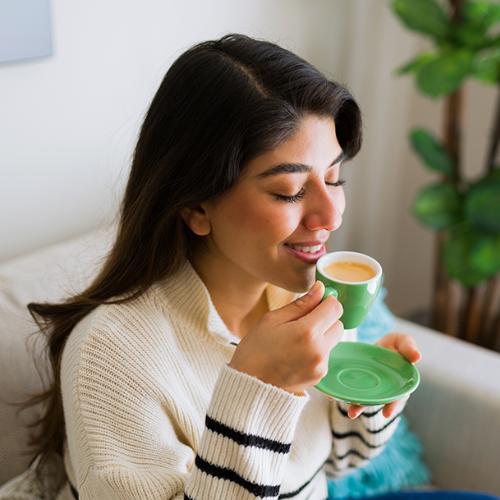 Młoda kobieta pijąca espresso w zielonej filiżance. Fot. Materiały partnera