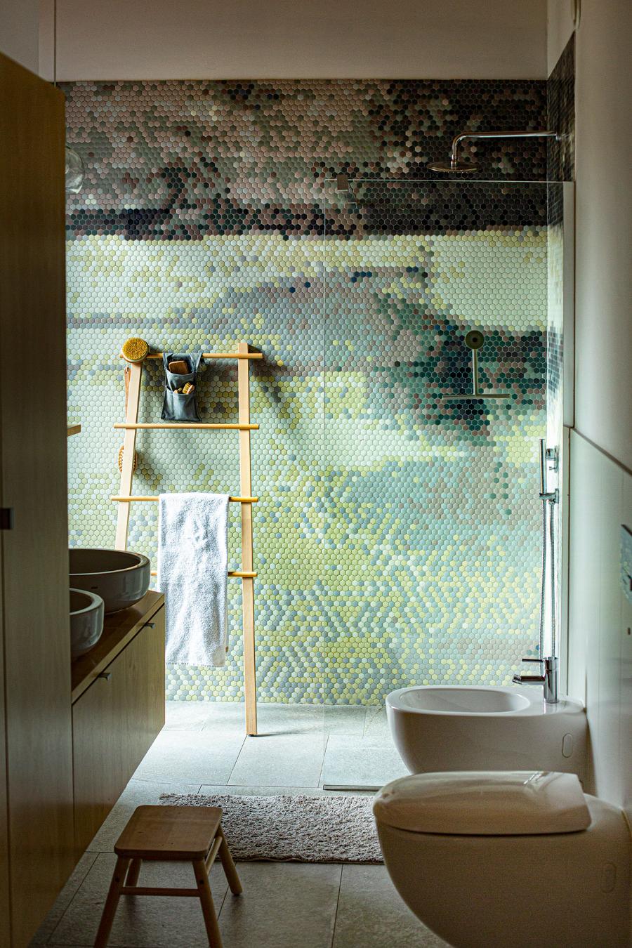 Spod prysznica można wyjść prosto na ogród, z okna roztacza się piękny widok na pobliskie jezioro. Konkuruje z nim malarska mozaika, którą na ścianach łazienki ułożyła firma Trufle z Katowic.