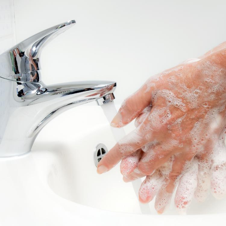 Frau wäscht sich mit fließendem wasser und Seife die Hände. Schutz vor Infektion der neuen Grippe.