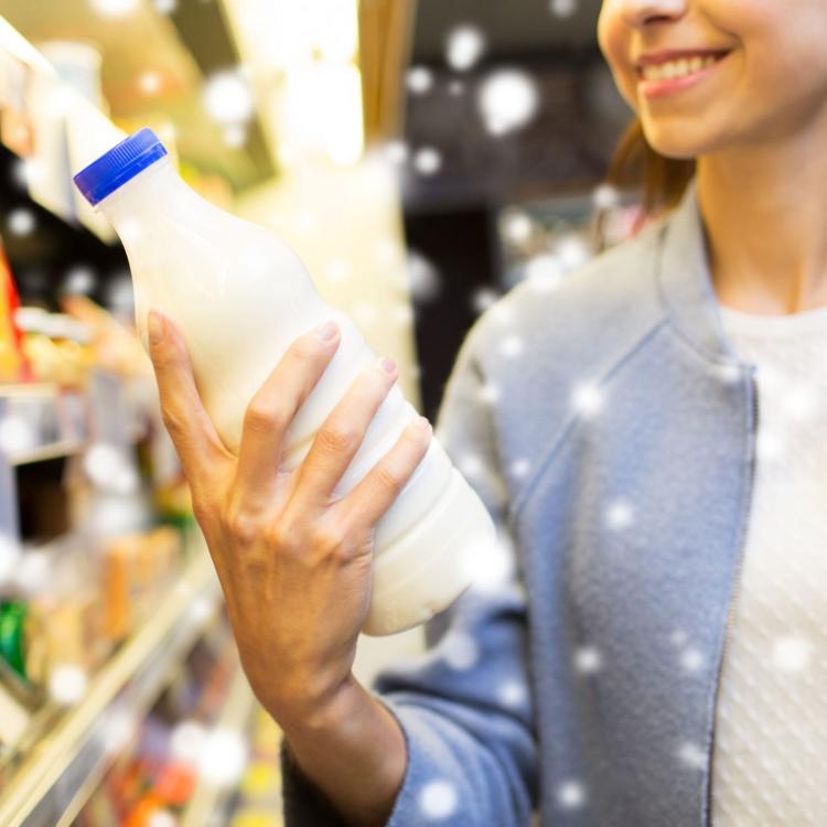 50182274 - sale, shopping, consumerism, food and people concept - close up of happy young woman holding milk bottle in market or grocery store over snow effect