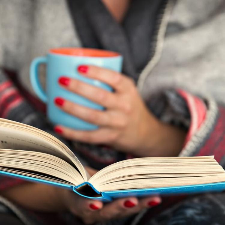 Zaszyć się pod ciepłym kocem z kubkiem parującego napoju w dłoni i zagłębić we wciągającej lekturze – to dla wielu osób idealny scenariusz na chłodny, jesienny dzień. (Fot. iStock)