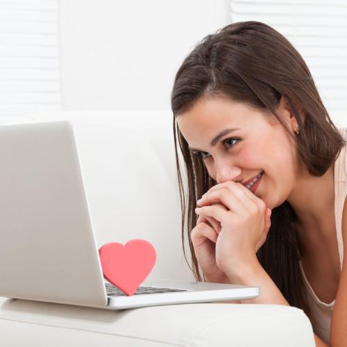 30787434 - side view of beautiful young woman dating online on laptop at home