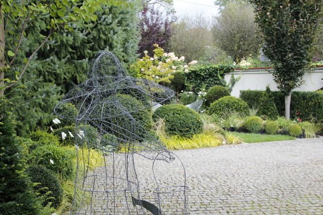 Damę ze stalowego drutu, popularny detal w ogrodach w stylu angielskim, wykonała mąż Danuty Młoźniak, Witold. (Fot. archiwum prywatne)