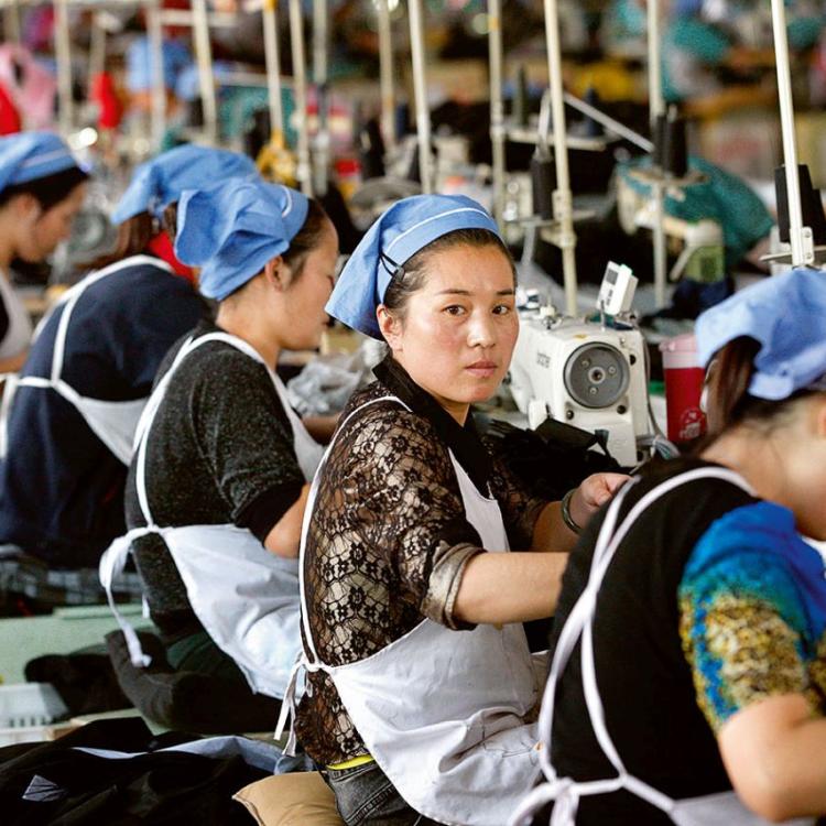 Kobiety pracujące w fabryce sukna, prowincja Anhui, wschodnie Chiny (październik 2015). Fot. East News