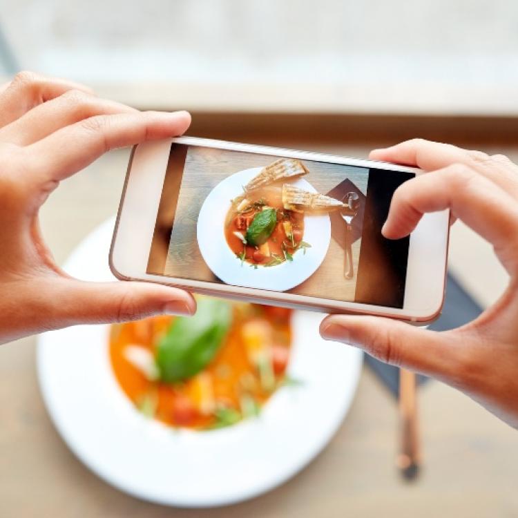 hands with smartphone photographing food