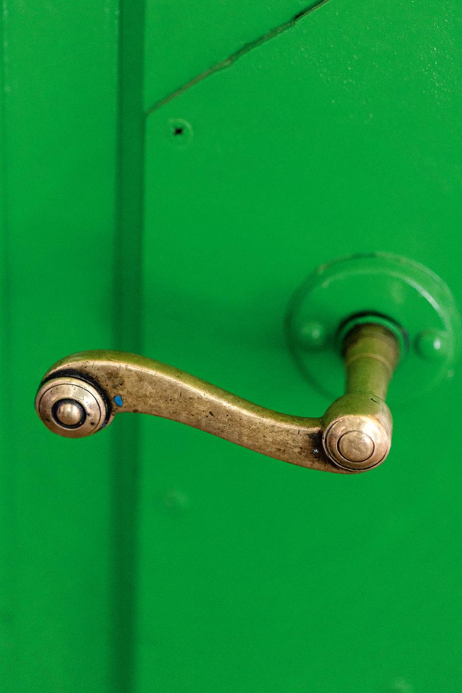 W domu udało się zachować oryginalne drzwi, ale stylowa klamka to już zdobycz z targu staroci. (Fot. proksaphotography.com)