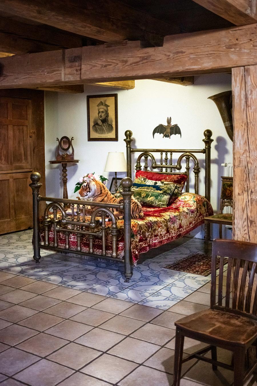 Niezwykłe metalowe łóżko dla gości – zakupione na pchlim targu w Stanach – które stoi na parterze w... salonie. Wiszący nad nim nietoperz to także praca Magdaleny Fangor.  (Fot. Robby Cyron)