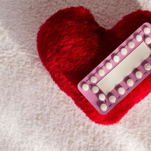 60676423 - medicine contraception love and birth control. oral contraceptive pills on red heart shaped little pillow