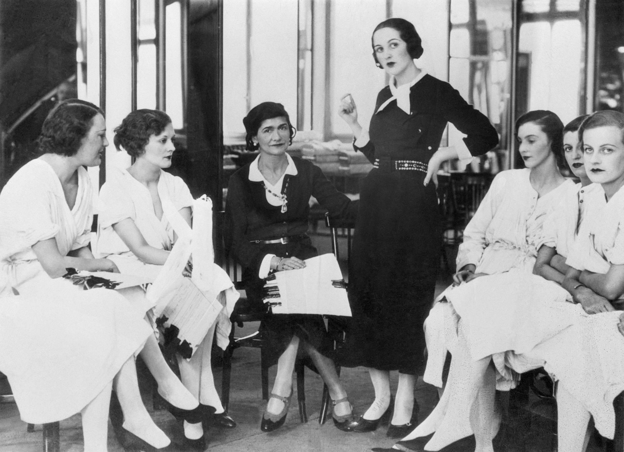  Lady Pamela Smith (w czarnym kostiumie) stoi w otoczeniu modelek. Obok Coco Chanel - była jedną z pierwszych arystokratek, które zaczęły pojawiać się w roli modelek. (Fot. Getty Images)