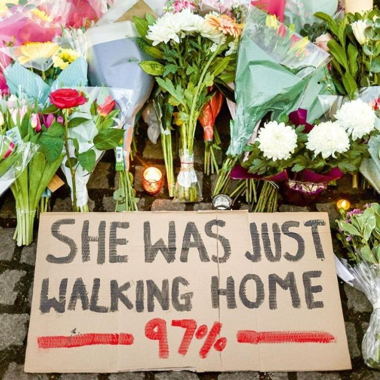 Sarah Everard nie miała krótkiej spódniczki, nie była pijana, szła główną ulicą, a nie boczną… Dostosowała się do „reguł gry”. I chyba właśnie dlatego jej przypadek wywołał taki odzew. Londyn, 13 marca 2021 roku. Transparent „Ona tylko szła do domu”, kwiaty i znicze w miejscu pamięci w Clapham Common. (Fot. Don Rutledge, HANNAH MCKAY/Reuters/Forum)